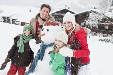 Österreich, Salzburg, Hüttau, Familie mit Schneemann, lächelnd - HHF003603