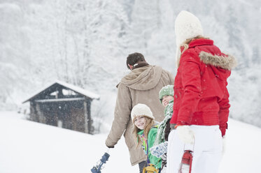 Österreich, Salzburg, Hüttau, Familie mit Laterne geht durch Schnee - HHF003604