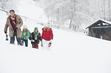 Austria, Salzburg, Hüttau, Family with lantern walking through snow - HHF003606