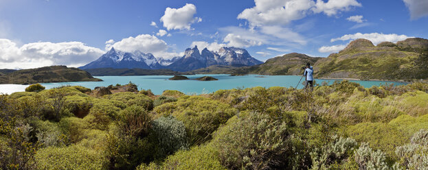 South America, Chile, Patagonia, Torres del Paine National Park, Cuernos del Paine from Lake Pehoe, female photographer standing beside lake - FOF003194