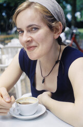 France, Mid adult woman in cafe with coffee, smiling, portrait - MUF001016