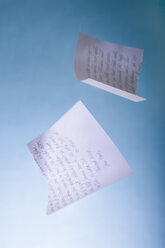 Torn love letter falling against blue background - MUF001034