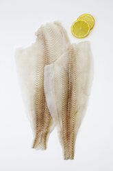 Slices of fresh halibut fish filet with lime, close up - CSF014876