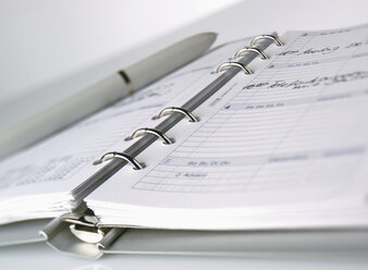 Close up of ring diary with pen against white background - WBF000990