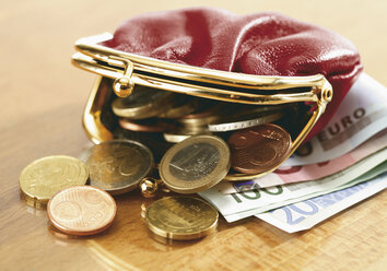 Nahaufnahme von Euro-Banknoten und Geldbörse, die Münzen verschüttet - WBF001016