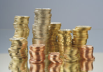 Close up of variety of euro coins stacked against grey background - WBF001018