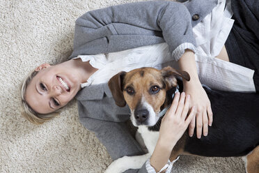 Deutschland, Bayern, München, Junge Frau spielt mit Hund, lächelnd - RBF000534