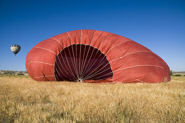 Turkey, Cappadocia, Goreme, View of hot air balloons landing in a field. - PSF000508
