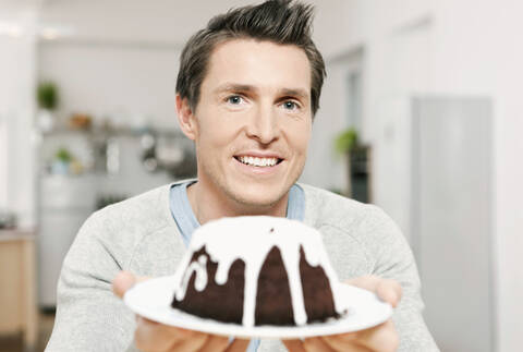 Deutschland, Köln, Mann hält Teller mit Kuchen, lizenzfreies Stockfoto