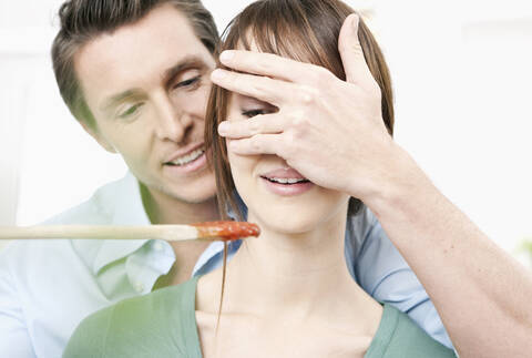 Germany, Cologne, Woman tasting sauce stock photo