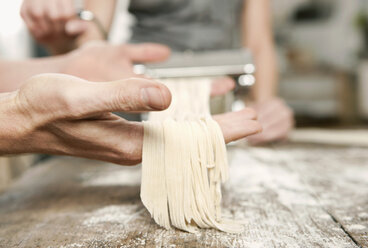 Germany, Cologne, Man and woman making pasta - FMKF000235