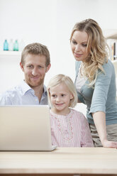 Germany, Bavaria, Munich, Family using laptop, smiling - RBF000555