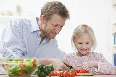 Germany, Bavaria, Munich, Father helping daughter to prepare salad, smiling - RBF000558