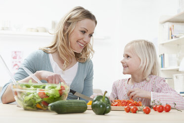 Germany, Bavaria, Munich, Mother and daughter preparing salad, smiling - RBF000560