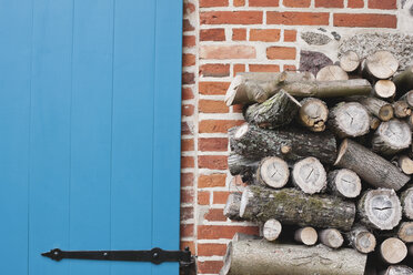 Germany, Kratzeburg, Stack of firewood near country house - WESTF016581