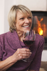Deutschland, Kratzeburg, Ältere Frau hält Weinglas, lächelnd - WESTF016607