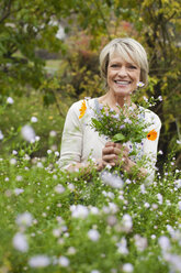 Germany, Kratzeburg, Senior woman in garden, smiling, portrait - WESTF016609