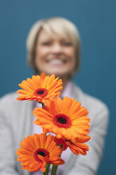 Germany, Kratzeburg, Senior woman with bunch of flowers, smiling - WESTF016618