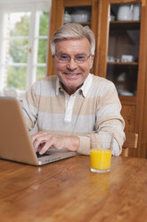 Deutschland, Kratzeburg, Senior Mann mit Laptop, lächelnd, Porträt - WESTF016623