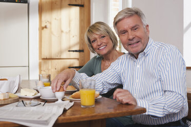 Deutschland, Kratzeburg, Seniorpaar beim Frühstück, lächelnd, Porträt - WESTF016651