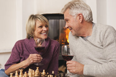 Germany, Kratzeburg, Senior couple with wine glass and chess board - WESTF016686