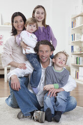 Germany, Bavaria, Munich, Family sitting togetherness on floor, smiling, portrait - RBF000598