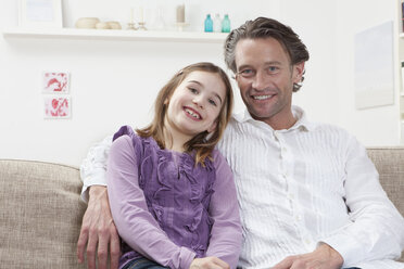Germany, Bavaria, Munich, Father with daughter sitting on couch, smiling, portrait - RBF000604