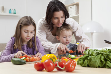 Deutschland, Bayern, München, Mutter hilft Kindern bei der Zubereitung von Salat - RBF000614