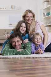 Germany, Bavaria, Munich, Family lying on carpet, smiling, portrait - RBF000646