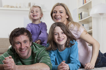 Deutschland, Bayern, München, Familie zusammen auf Teppich liegend, lächelnd, Porträt - RBF000665