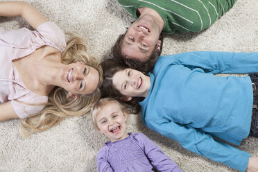 Germany, Bavaria, Munich, Family lying on carpet, laughing, portrait - RBF000669