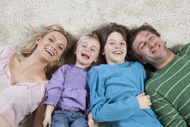 Germany, Bavaria, Munich, Family lying on carpet, laughing, portrait - RBF000616