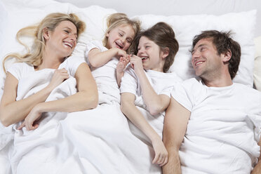 Germany, Bavaria, Munich, Family lying in bed, laughing - RBF000622