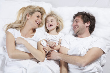 Germany, Bavaria, Munich, Family lying in bed, laughing - RBF000623