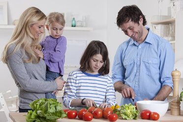 Germany, Bavaria, Munich, Son preparing salad with father, mother and daughter standing besides them - RBF000629