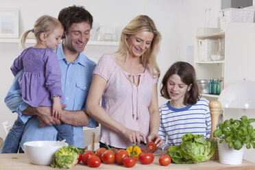 Deutschland, Bayern, München, Mutter bereitet Salat mit Sohn, Vater und Tochter stehen daneben - RBF000634