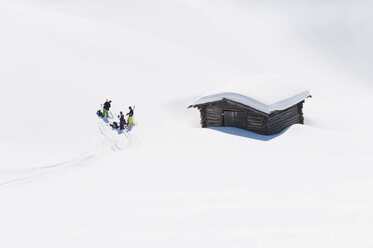 Italien, Trentino-Südtirol, Südtirol, Bozen, Seiser Alm, Gruppe von Menschen in der Nähe des Hauses auf Skitour - MIRF000133