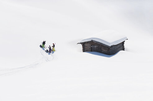 Italien, Trentino-Südtirol, Südtirol, Bozen, Seiser Alm, Gruppe von Menschen in der Nähe des Hauses auf Skitour - MIRF000133