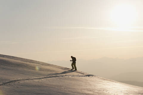Italien, Trentino-Südtirol, Südtirol, Bozen, Seiser Alm, Mittlerer erwachsener Mann auf Skitour am Morgen, lizenzfreies Stockfoto