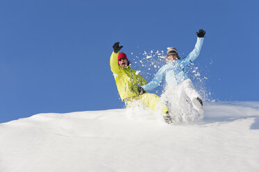 Italien, Trentino-Südtirol, Südtirol, Bozen, Seiser Alm, Mann und Frau springen auf Schnee - MIRF000185