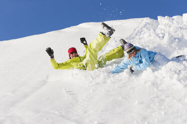 Italien, Trentino-Südtirol, Südtirol, Bozen, Seiser Alm, Mann und Frau springen auf Schnee - MIRF000186