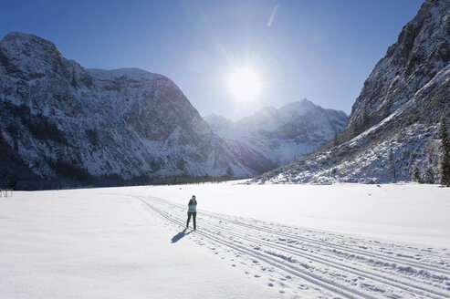 Deutschland, Bayern, Ältere Frau beim Skilanglauf mit Karwendalgebirge im Hintergrund - MIRF000208