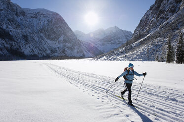 Deutschland, Bayern, Ältere Frau beim Skilanglauf mit Karwendalgebirge im Hintergrund - MIRF000209