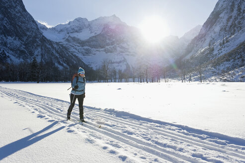 Deutschland, Bayern, Ältere Frau beim Skilanglauf mit Karwendalgebirge im Hintergrund - MIRF000212