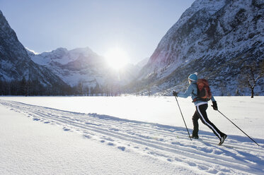 Deutschland, Bayern, Ältere Frau beim Skilanglauf mit Karwendalgebirge im Hintergrund - MIRF000213