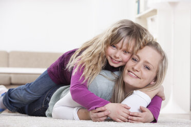 Germany, Bavaria, Munich, Mother and daughter lying at home - RBF000670