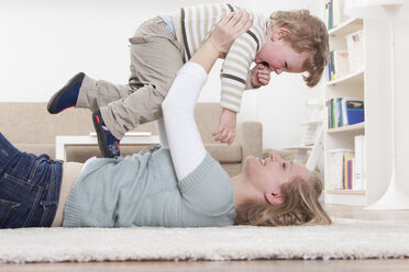 Germany, Bavaria, Munich, Mother and son playing on floor at home - RBF000677