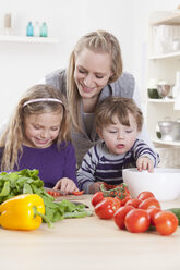 Germany, Bavaria, Munich, Mother, daughter and son preparing salad - RBF000682