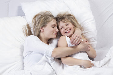 Germany, Bavaria, Munich, Mother and daughter lying on bed - RBF000685