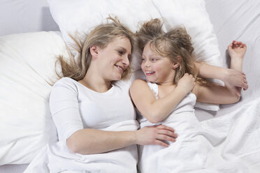 Germany, Bavaria, Munich, Mother and daughter lying on bed - RBF000686